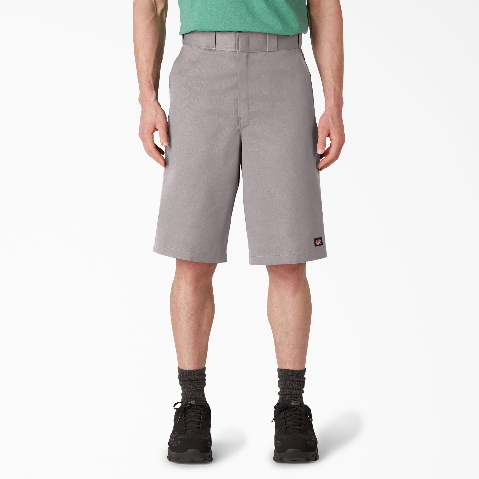 Person wearing 42283 13" Loose Fit Work Short Shorts Silver Shorts, Man wearing gray shorts and green shirt standing against