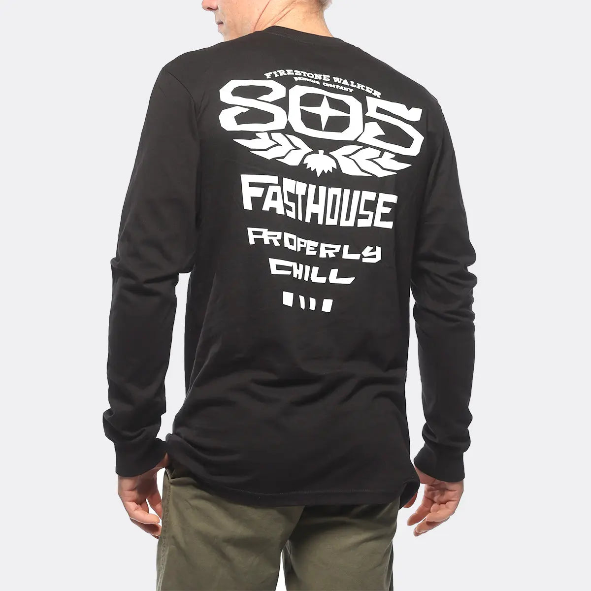Person wearing 805 Gravel Black L/S Tee, Wearer standing outdoors against neutral light background, showing back graphic