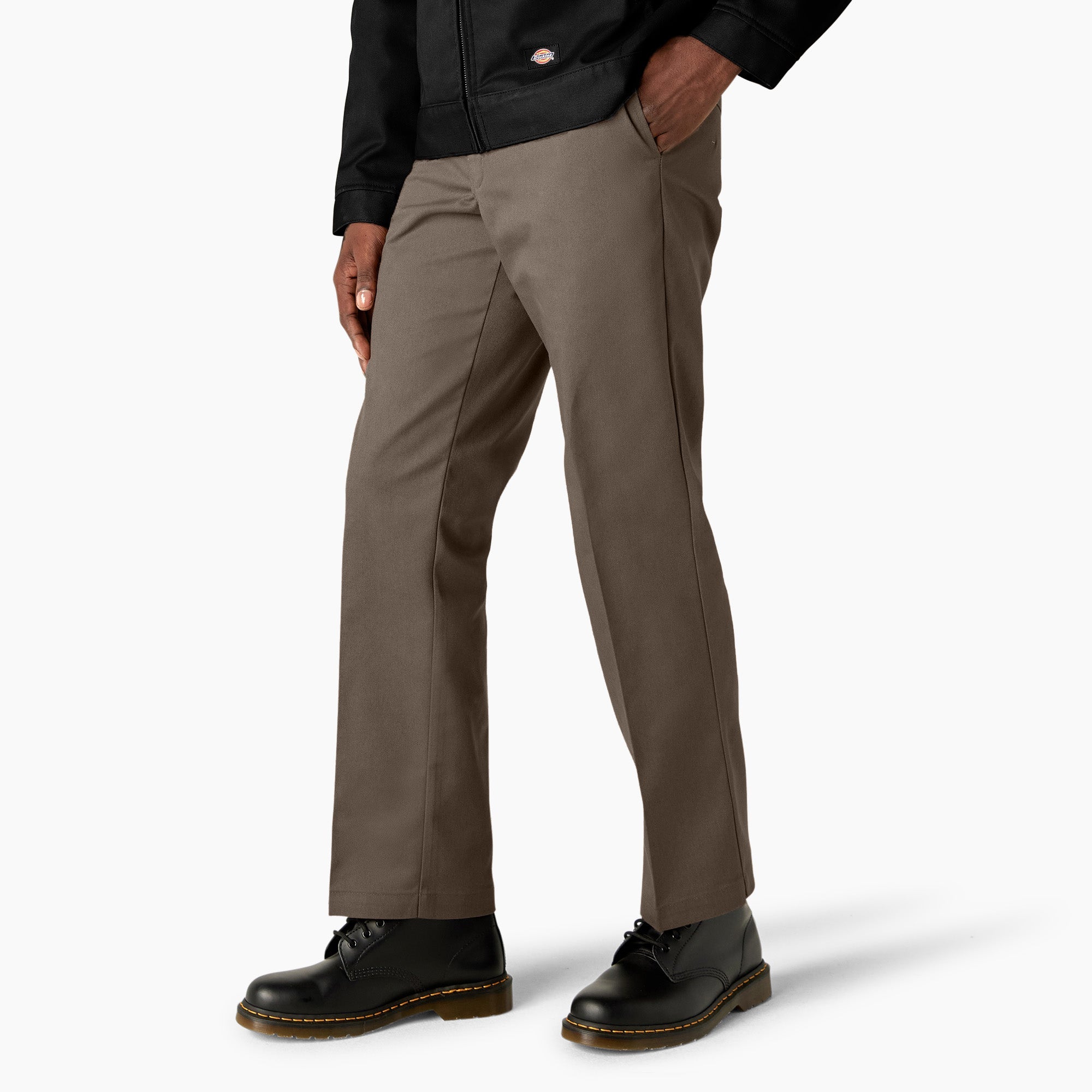 Person wearing 874 Original Work Pant Pants Black Pants, Khaki work pants styled with black jacket and black boots against