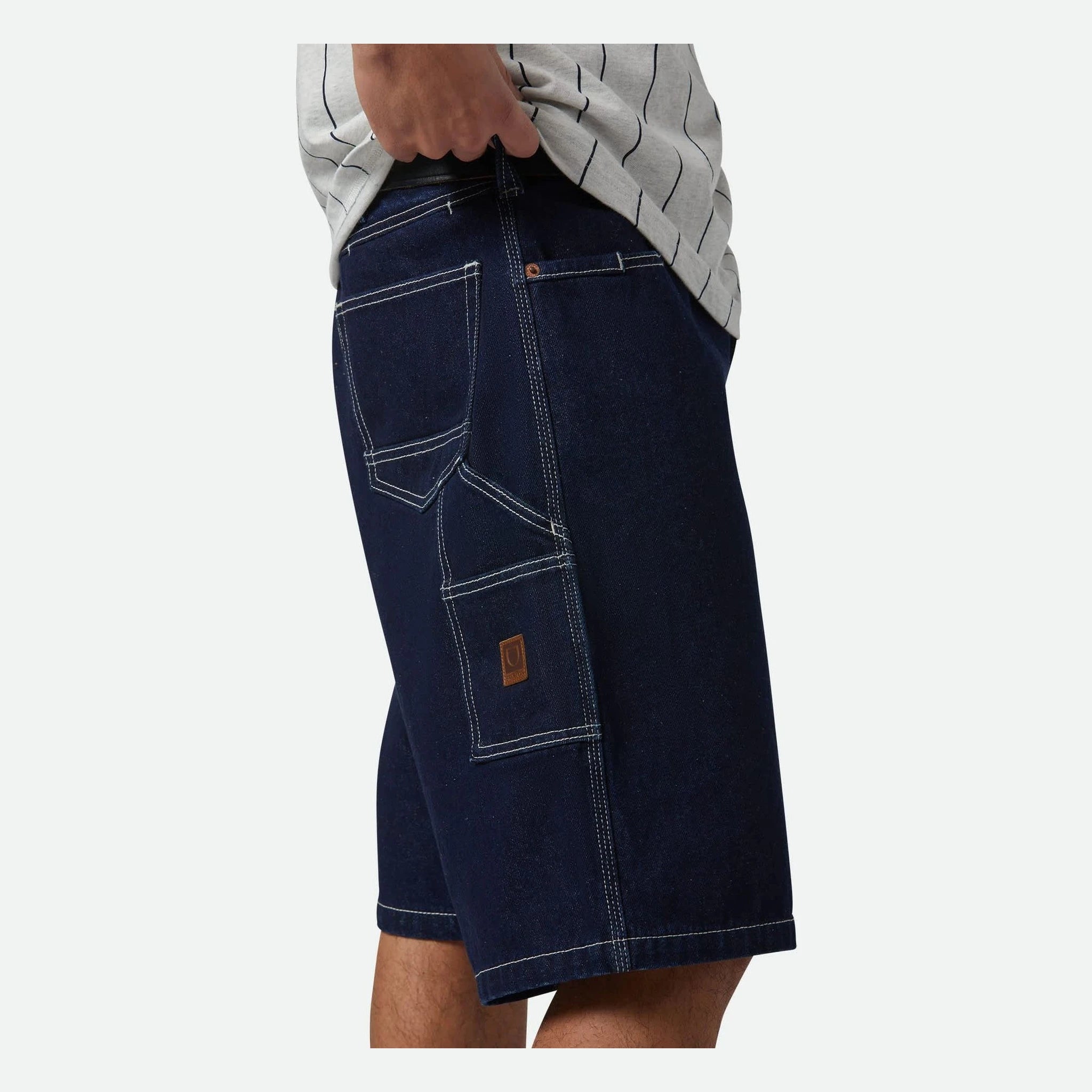 Person wearing Builders Carpenter Baggy Short Rinse Denim Shorts Shorts, Man wearing navy denim shorts with light gray