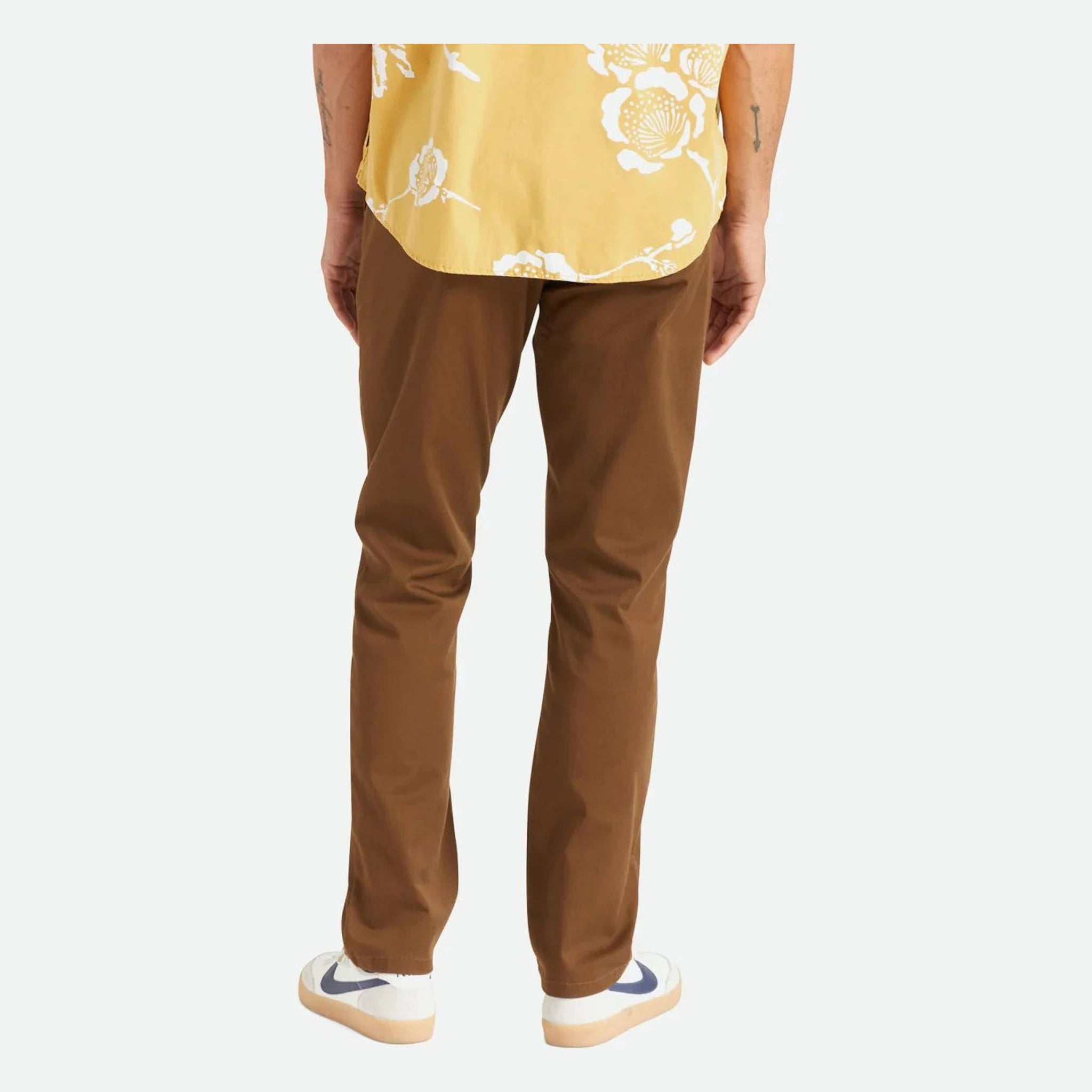 Person wearing Choice Chino Pant Pants Black Pants, Man standing against plain white backdrop wearing brown chinos and