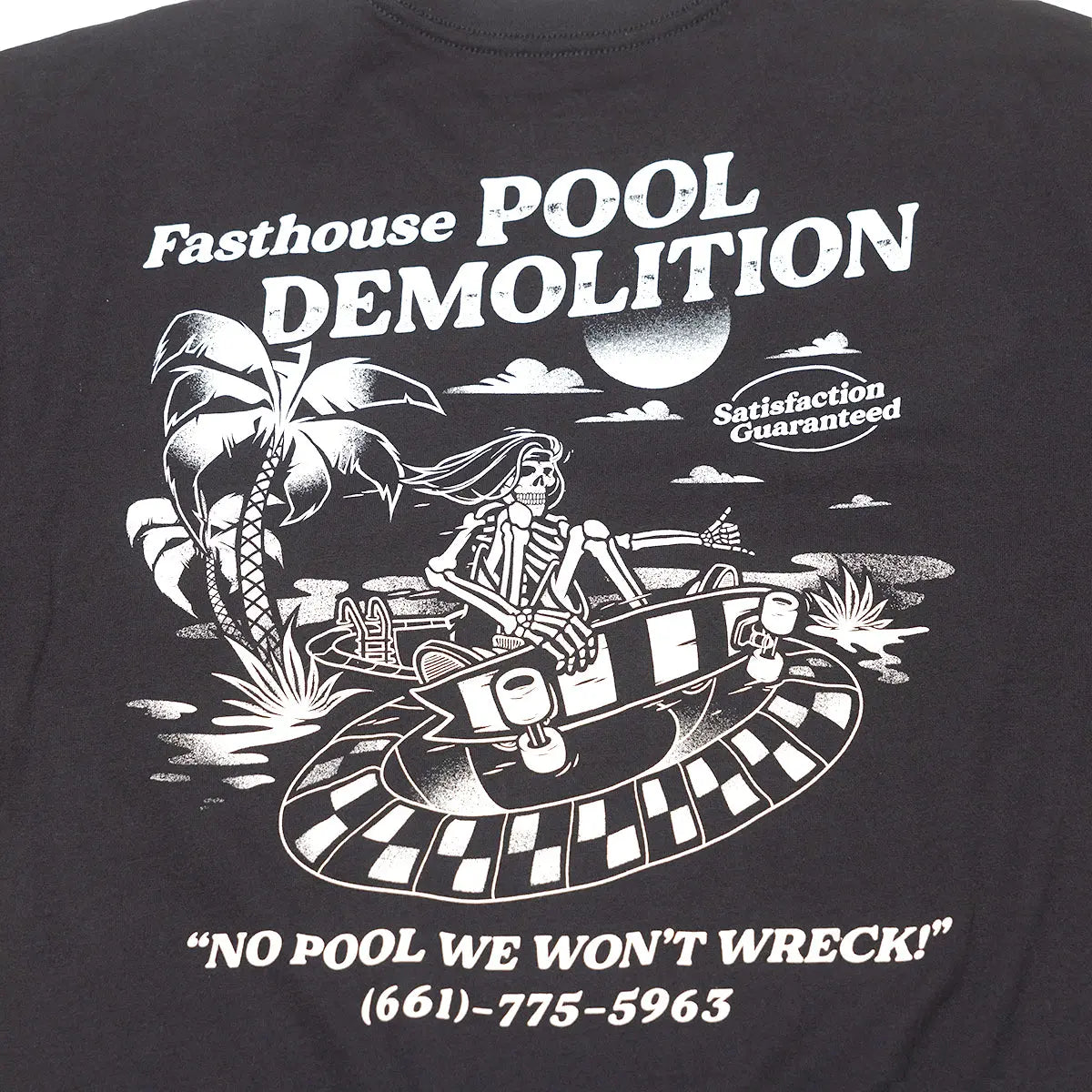 Close-up of Demolition Black Tee showing White halftone graphic of skeletal figure piloting checkered hovercraft over desert