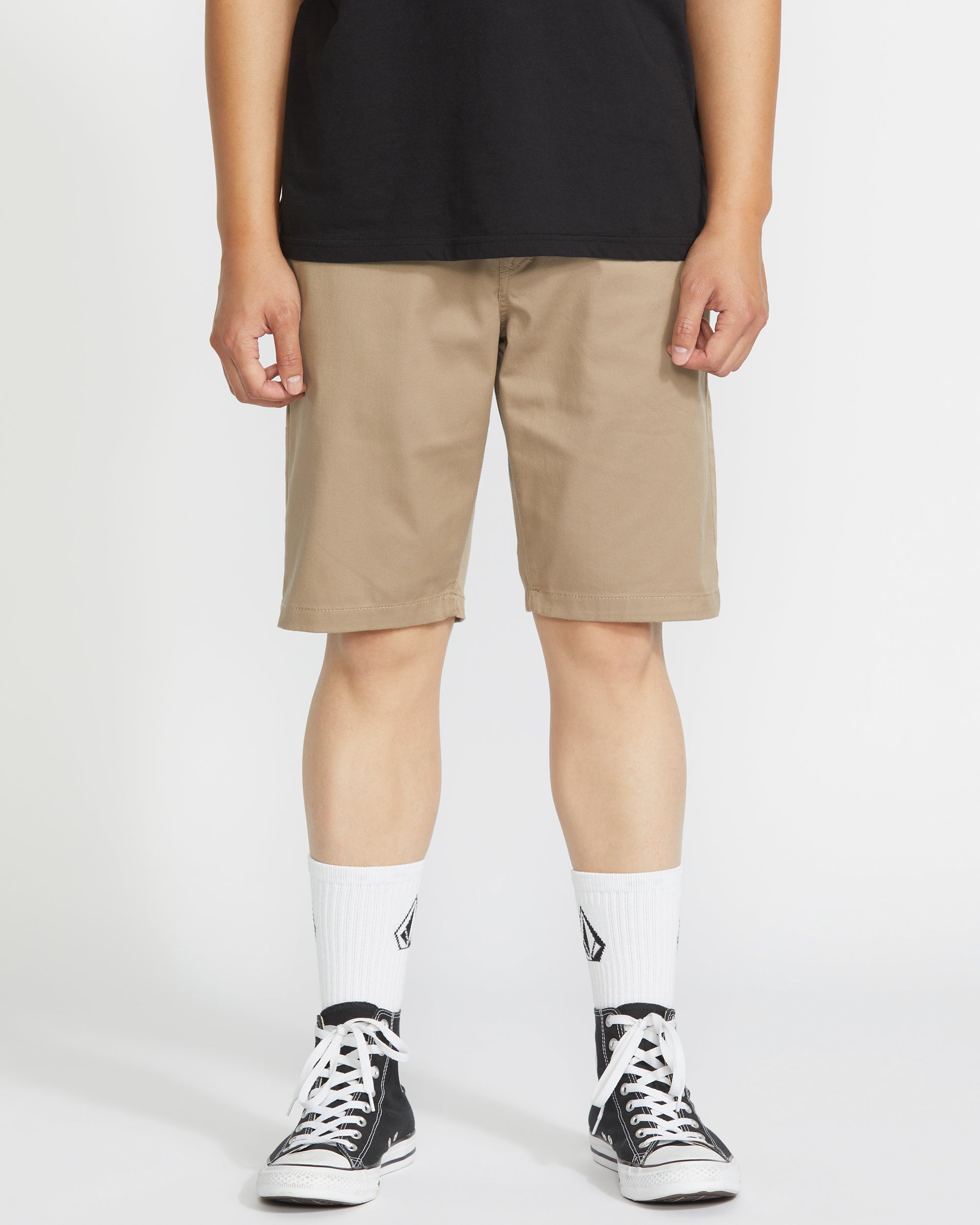 Person wearing Frickin Modern Short Shorts Black Shorts, Khaki shorts styled with black tee, white crew socks, and black