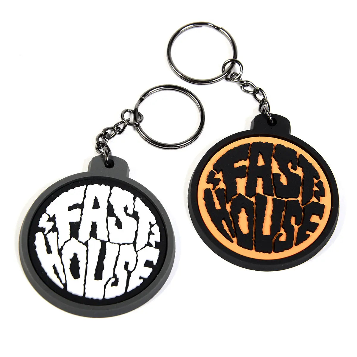 Grime Keychain Accessory front view, Two rubber keychains with cracked text design, one white on black, one gold on black,