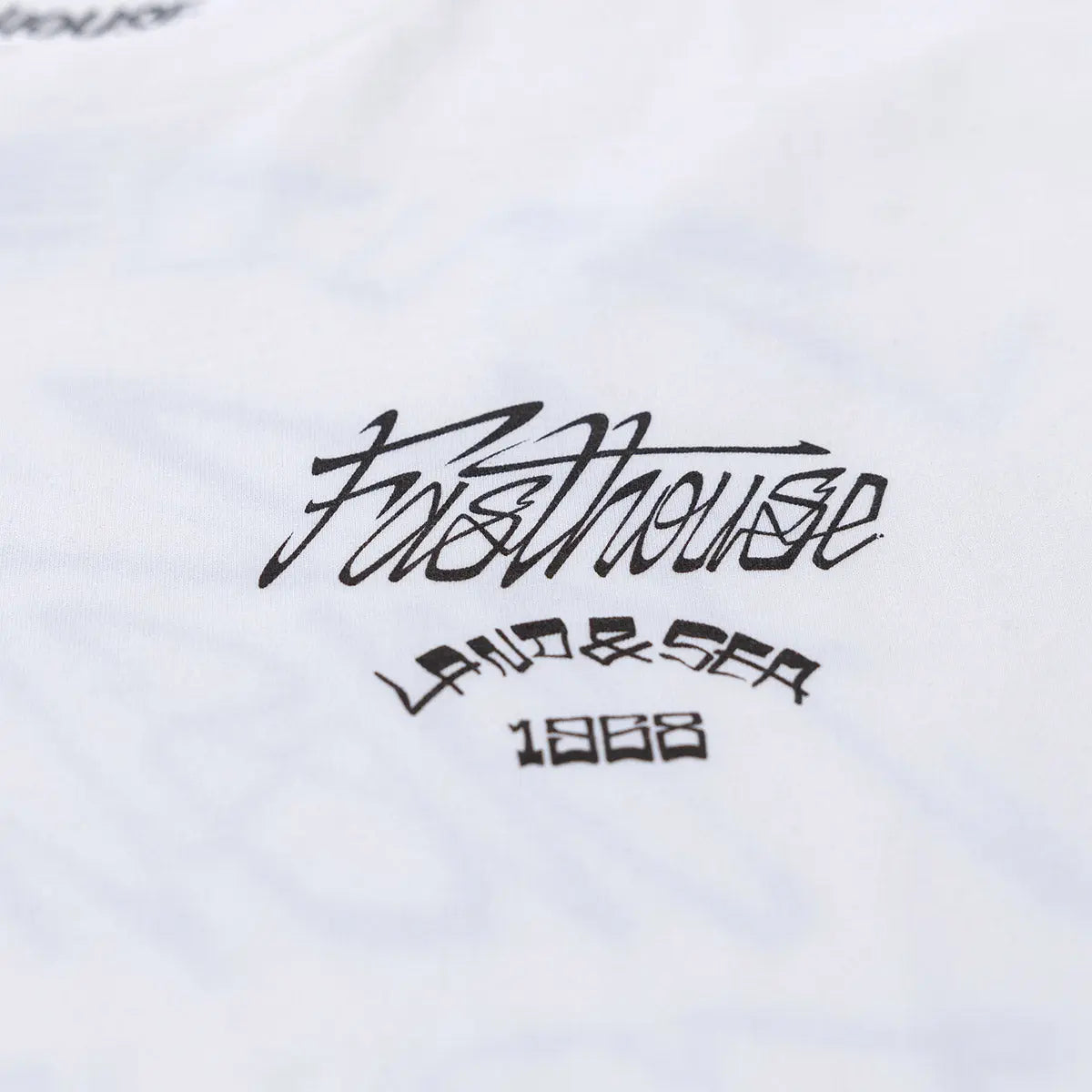 Close-up of Horizon Black Tee showing Black script text and year mark printed on white fabric surface - Slowride Supply