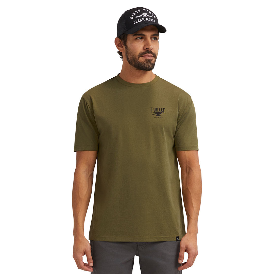 Person wearing Pay Me Military Tee, Man wearing olive tee against plain white studio background - Slowride Supply