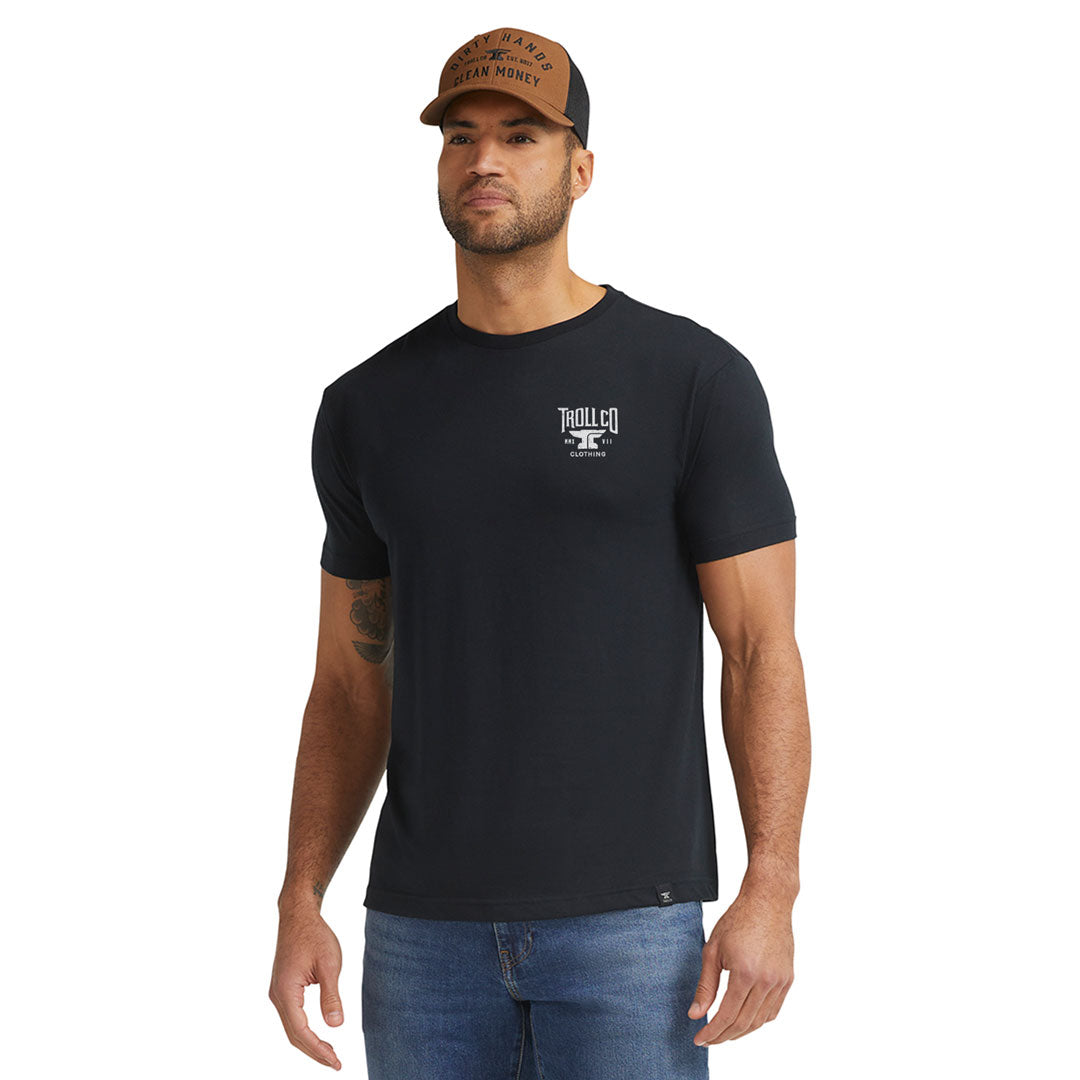 Person wearing Pay Me Military Tee, Man wearing black tee standing against white studio backdrop - Slowride Supply