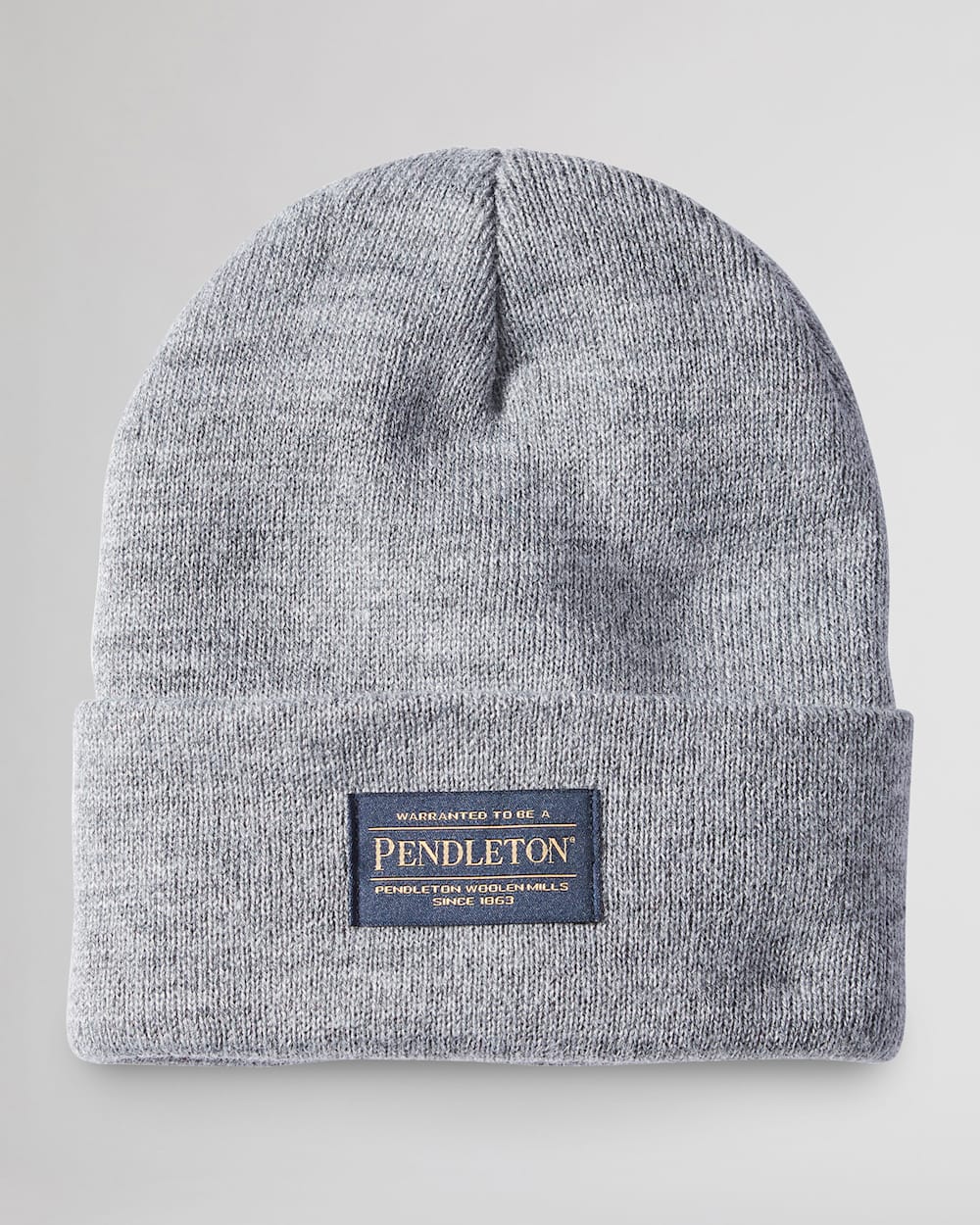 Close-up of Red Beanie showing Light gray ribbed knit with navy woven label featuring gold text and "since 1869" date stamp