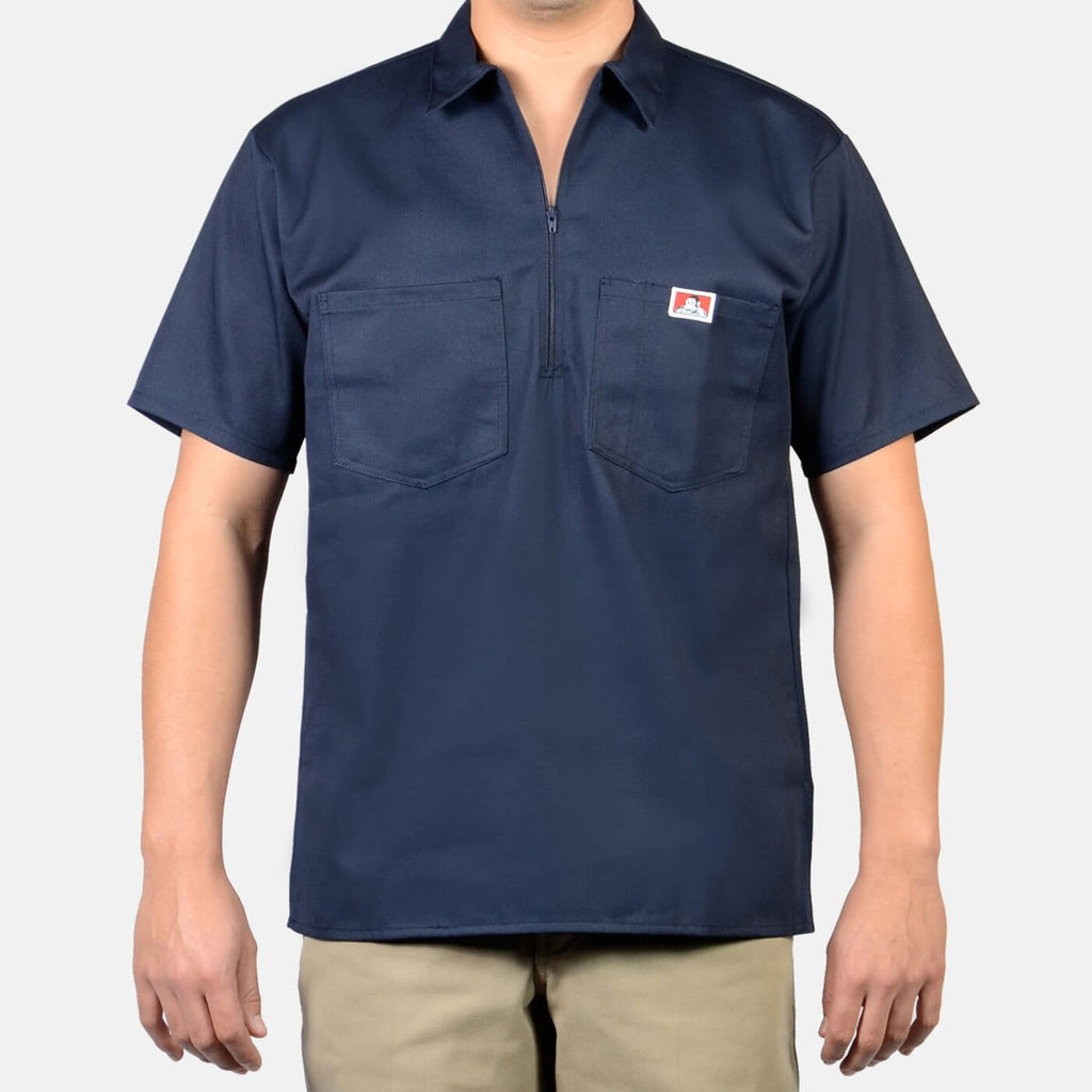 Person wearing Short Sleeve Solid Half Zip S/S Woven Black S/S Woven, Navy work shirt displayed on a model against neutral
