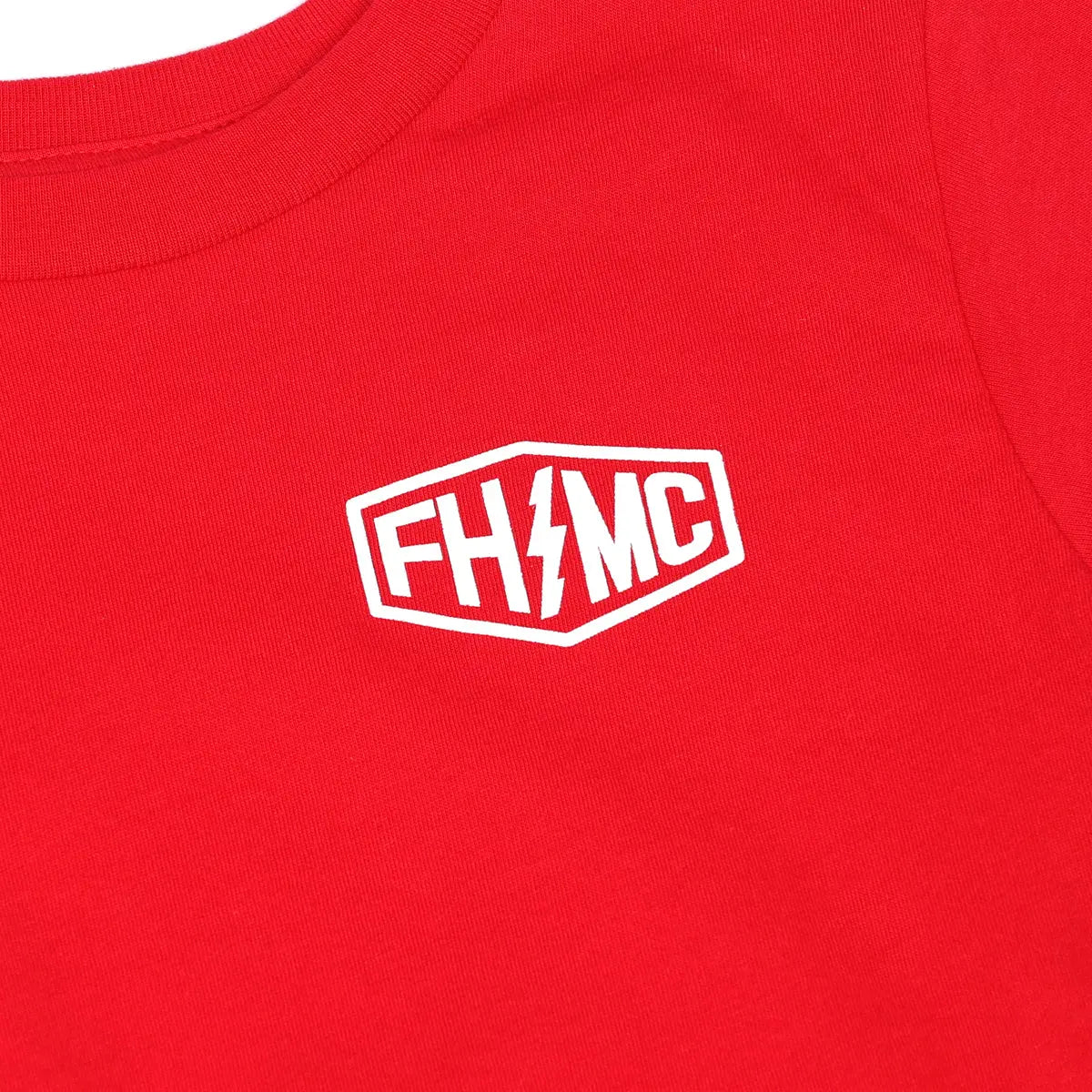 Close-up of Toddler Gibson Tee Kids Red Kids Tee showing White embroidered logo patch with lightning bolt detail on red