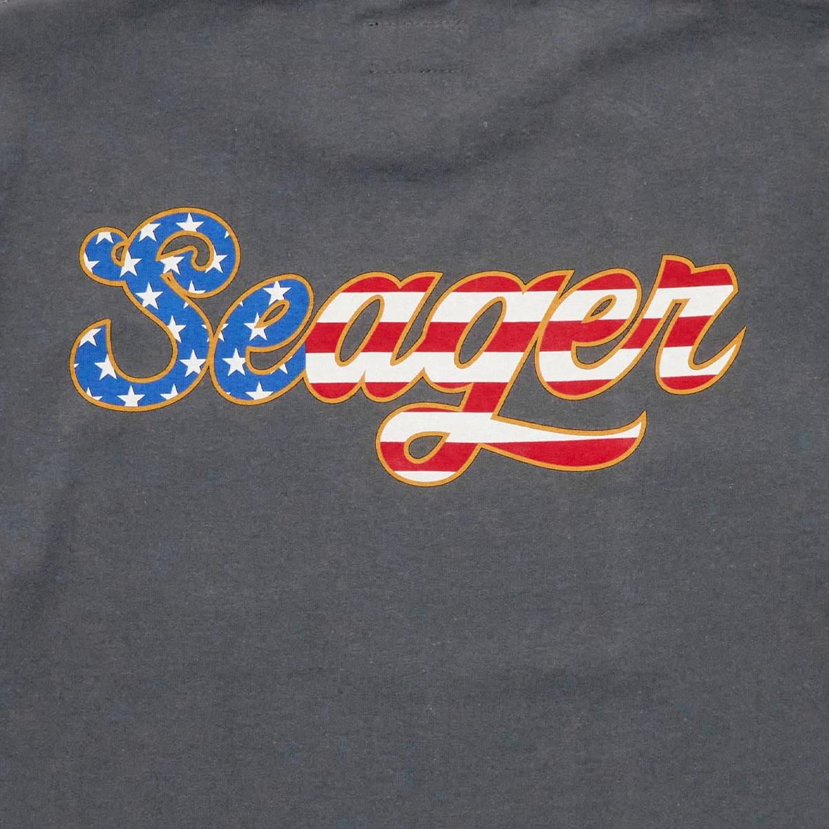 Close-up of USA Russ Vintage Black Tee showing Embroidered script logo with blue star-filled S, red and white striped