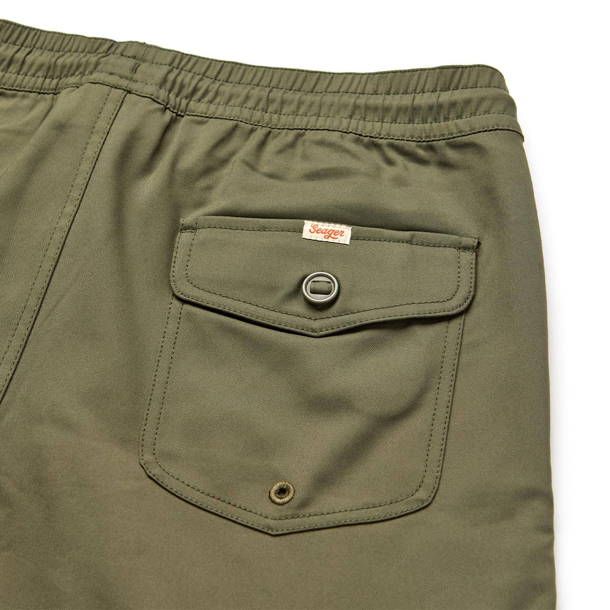 Close-up of Yuma Shorts Dark Olive Shorts showing Patch pocket with metal snap closure and woven label at waistband -