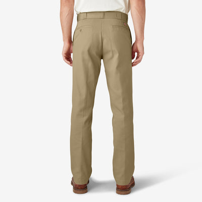 Person wearing 874 Original Work Pant Pants Black Pants, Man standing in neutral studio setting wearing khaki work pants