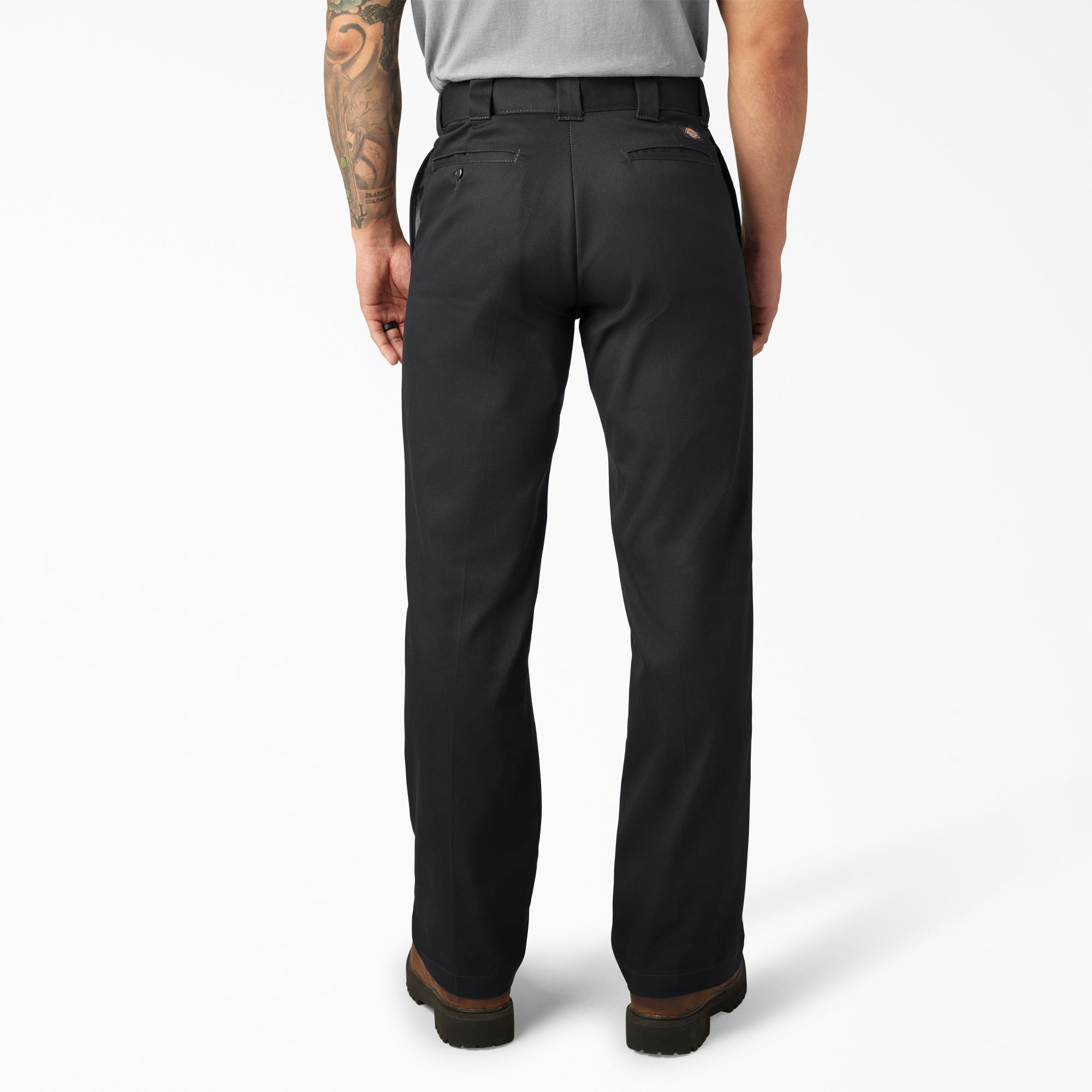 Person wearing 874f - Flex Work Pant Pants Dark Navy Pants, Black work pants with brown cuff detail shown from behind
