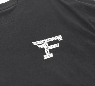 Close-up of Arthur Black Tee showing White speckled F logo with distressed texture on charcoal fabric - Slowride Supply