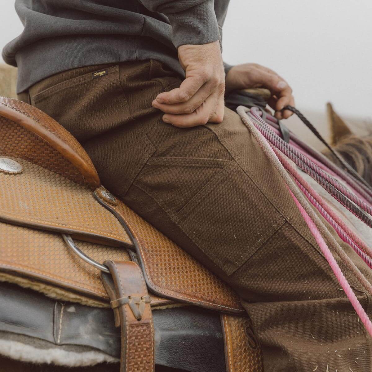 Back of Bison Canvas Pants Brown Pants, Brown canvas with visible seam stitching and small brand label at waistband -