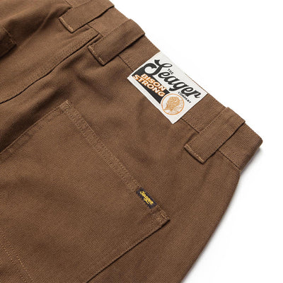 Close-up of Bison Canvas Pants Brown Pants showing Brown canvas with cargo pockets and embroidered brand script on leg -