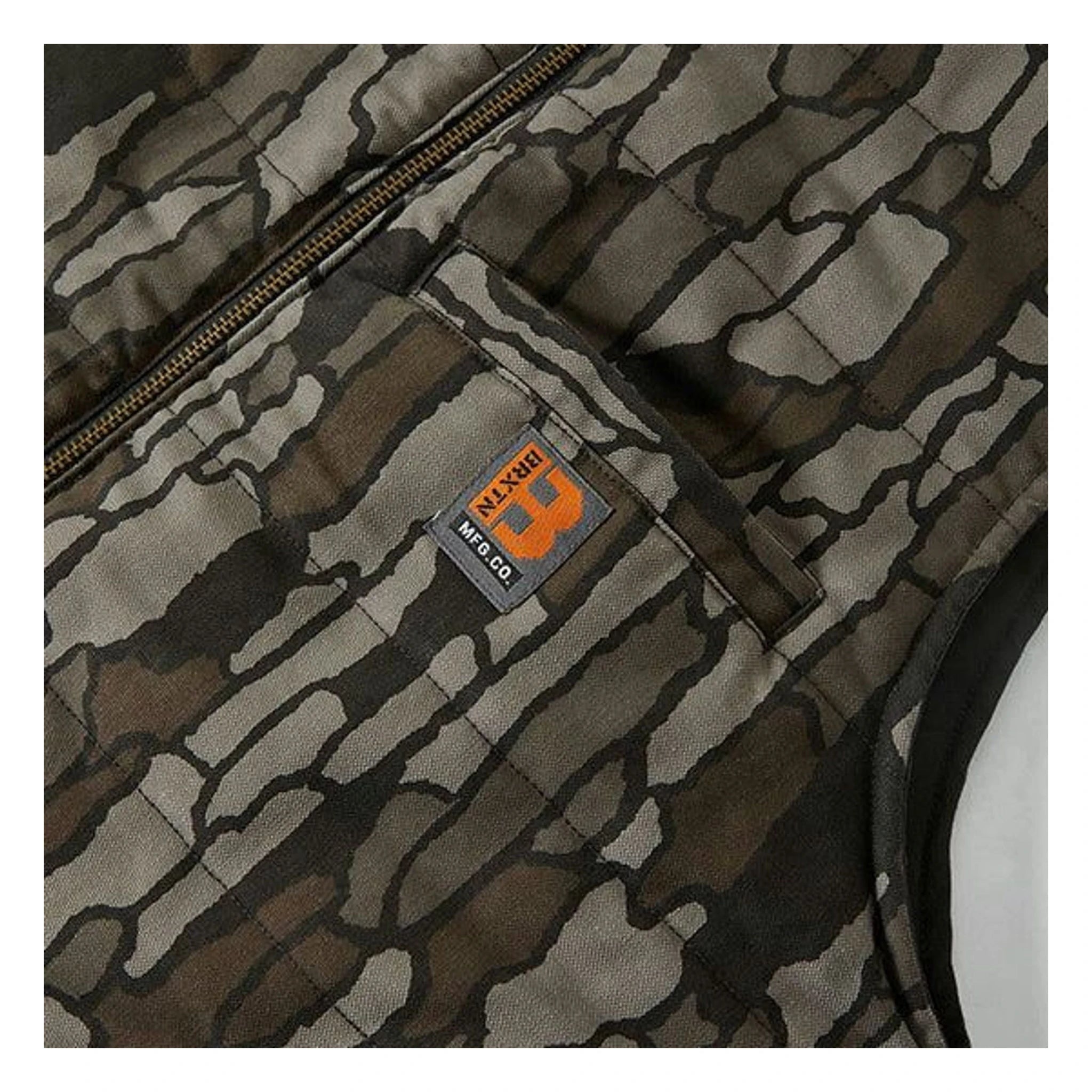 Care label on Builders Abraham Vest Bark Camo Vest Vest showing Small woven label with orange graphic and text on dark