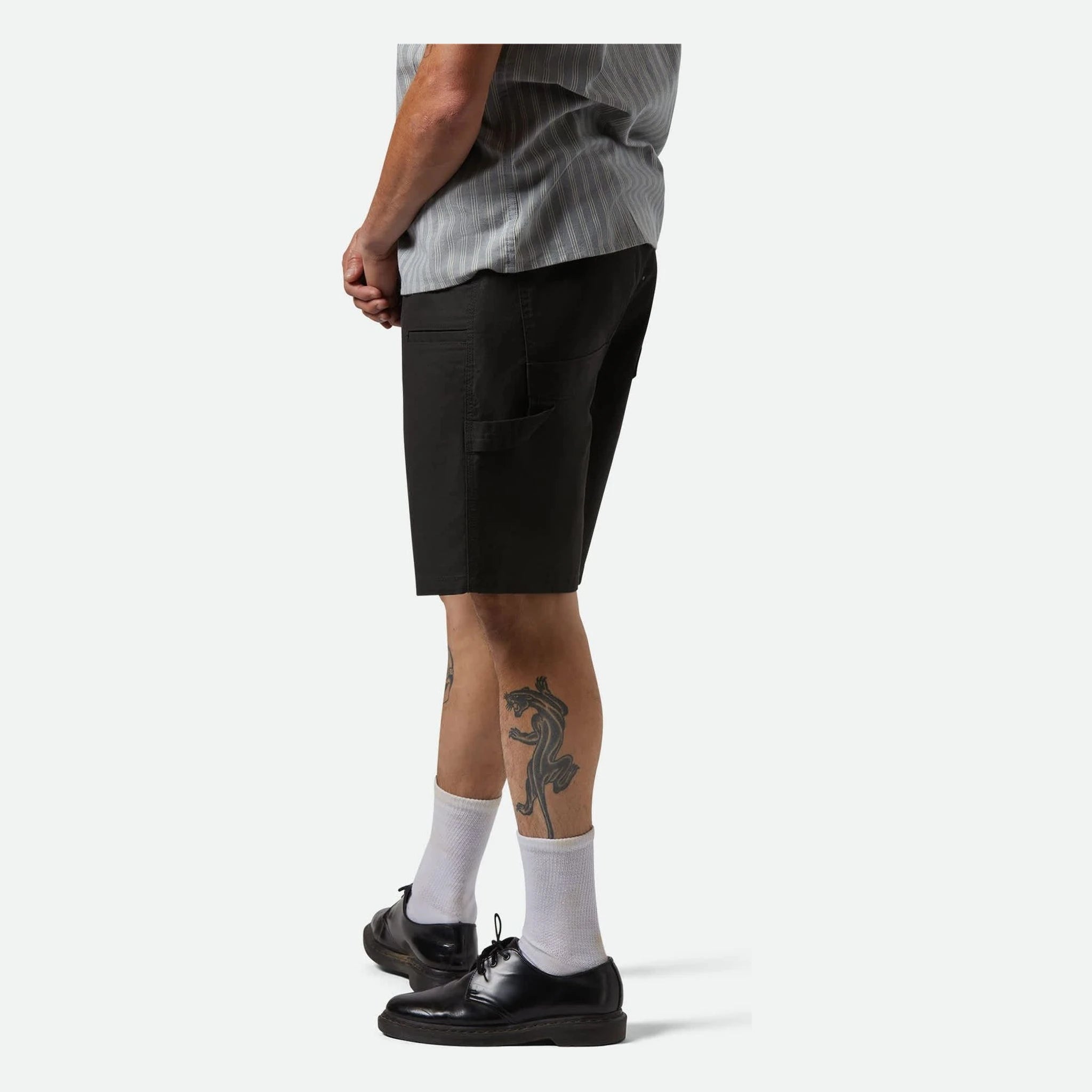 Person wearing Builders Carpenter Baggy Short Shorts Washed Black Shorts, Man wearing black shorts and white socks against