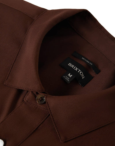Care label on Builders Olson S/s Woven Apparel Chocolate Apparel showing Black label with white text reading "BRIXTON" and