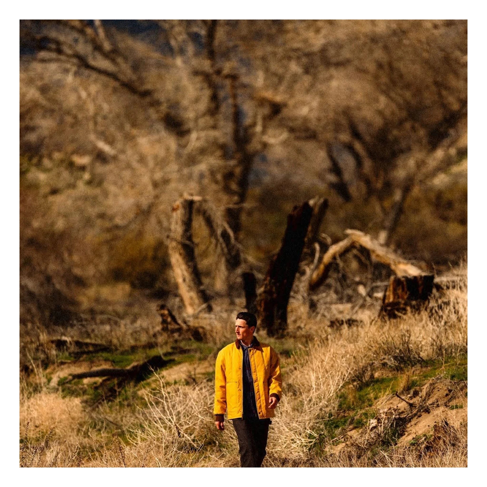 Person wearing Builders Ranch Jacket Spruce Yellow Jacket, Man wearing yellow jacket in desert canyon with bare rock
