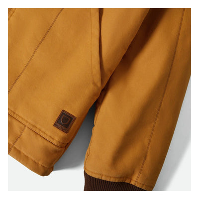 Close-up of Builders Ranch Jacket Spruce Yellow Jacket showing Small woven label patch on jacket cuff with embossed logo