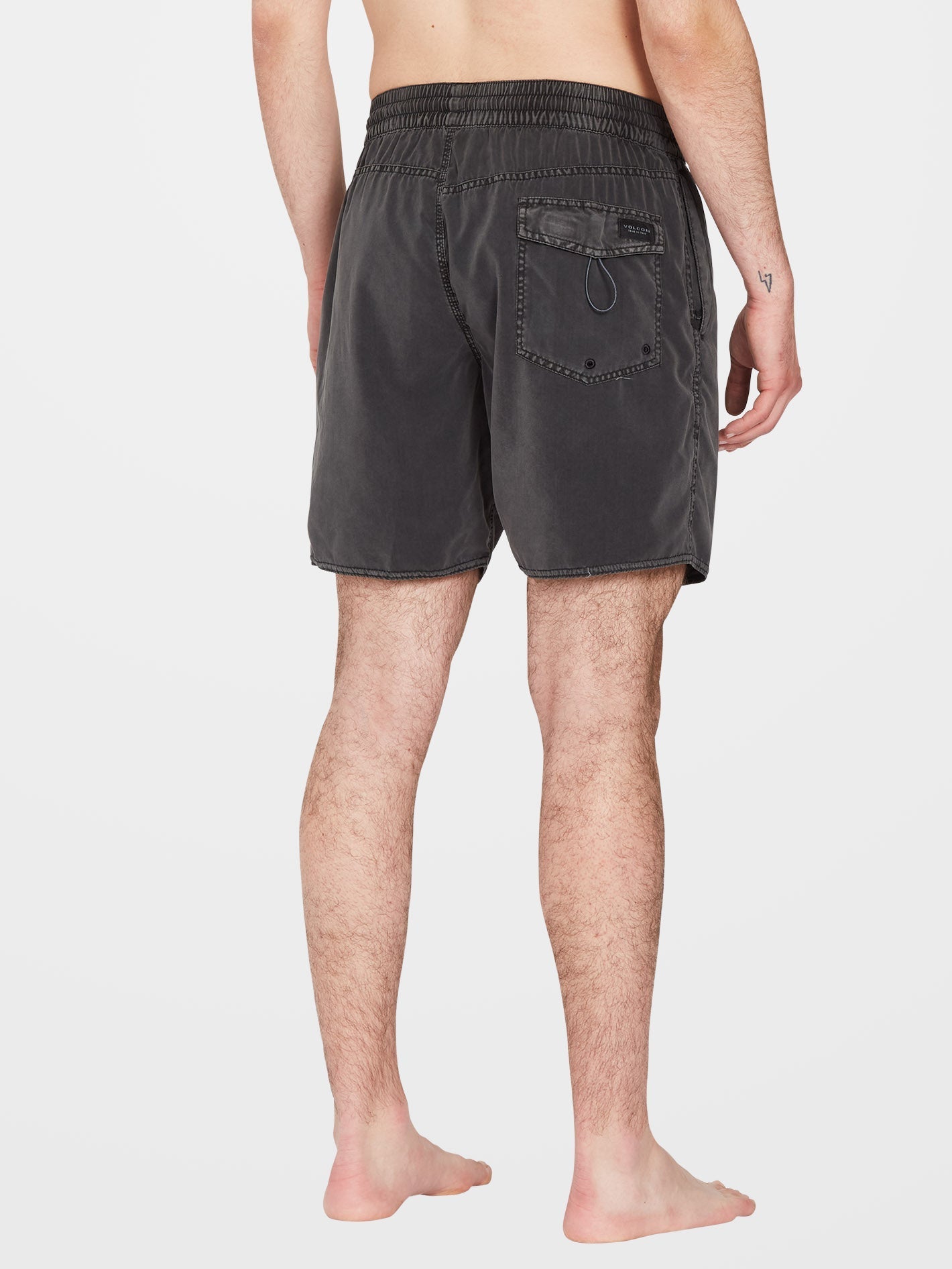 Person wearing Center Trunk 17" Boardshorts Black Boardshorts, Bare legs and neutral background, rear view showing back