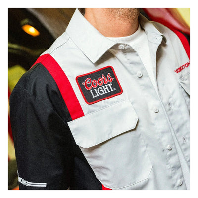 Person wearing Coors Light Shake Down S/S Woven Silver/black S/S Woven, Garage setting with headlight glow and vintage