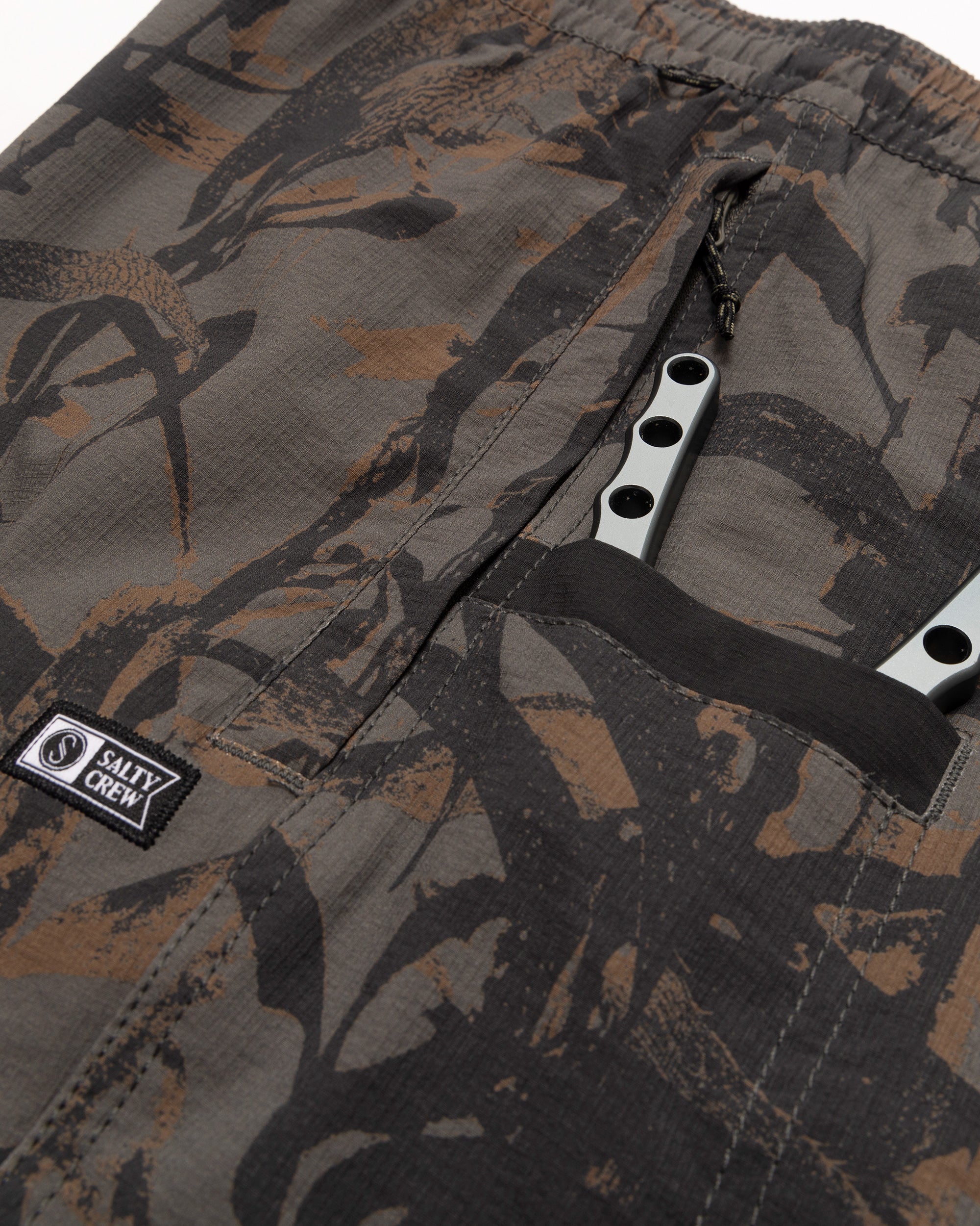 Close-up of Crew Boatshort 18" Boardshorts Camo Boardshorts showing White snap closure with black drawstring and woven label