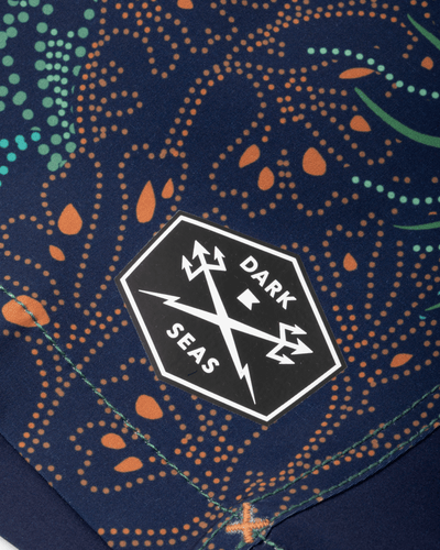 Close-up of Deepwater Boardshort Boardshorts Navy Boardshorts showing Hexagonal woven label with lightning bolt and trident