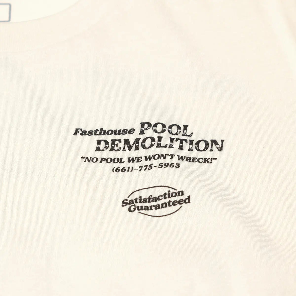 Close-up of Demolition Black Tee showing Black text print on cream ribbed fabric showing business name, tagline, phone