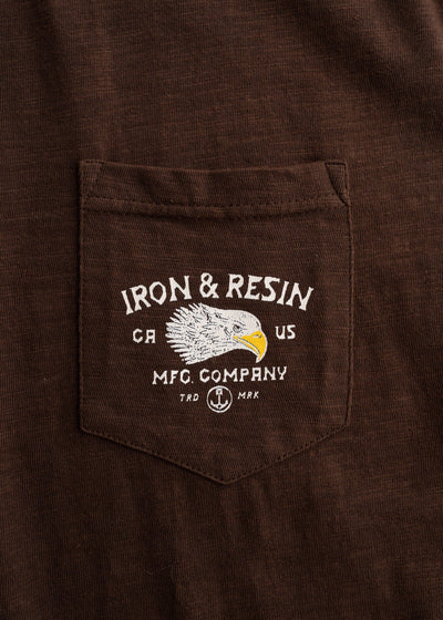 Close-up of Don't Ruin It Brown Tee showing Chest pocket with embroidered eagle head and "Iron & Resin" text graphic -