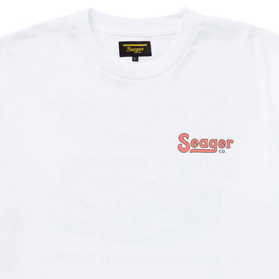 Close-up of Drifting the West White Tee showing Black woven label with gold script text and size L tag sewn at neckline -