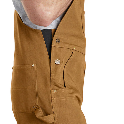 Person wearing Duck Bib Overalls Black Overalls, Worn by a person standing in neutral indoor setting against plain