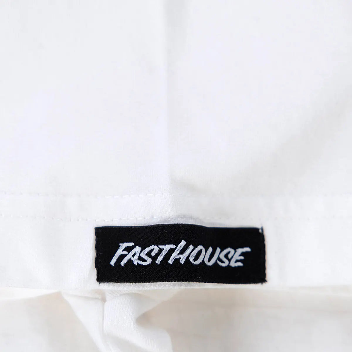 Care label on Flyer White Tee showing Black woven label with white embroidered italic script text - Slowride Supply