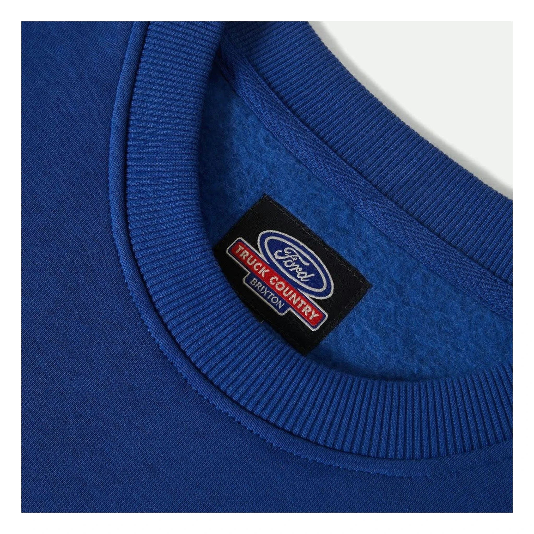 Close-up of Ford Number One Fleece Crew Ford Blue Crewneck showing Black woven label with oval logo and red text on ribbed