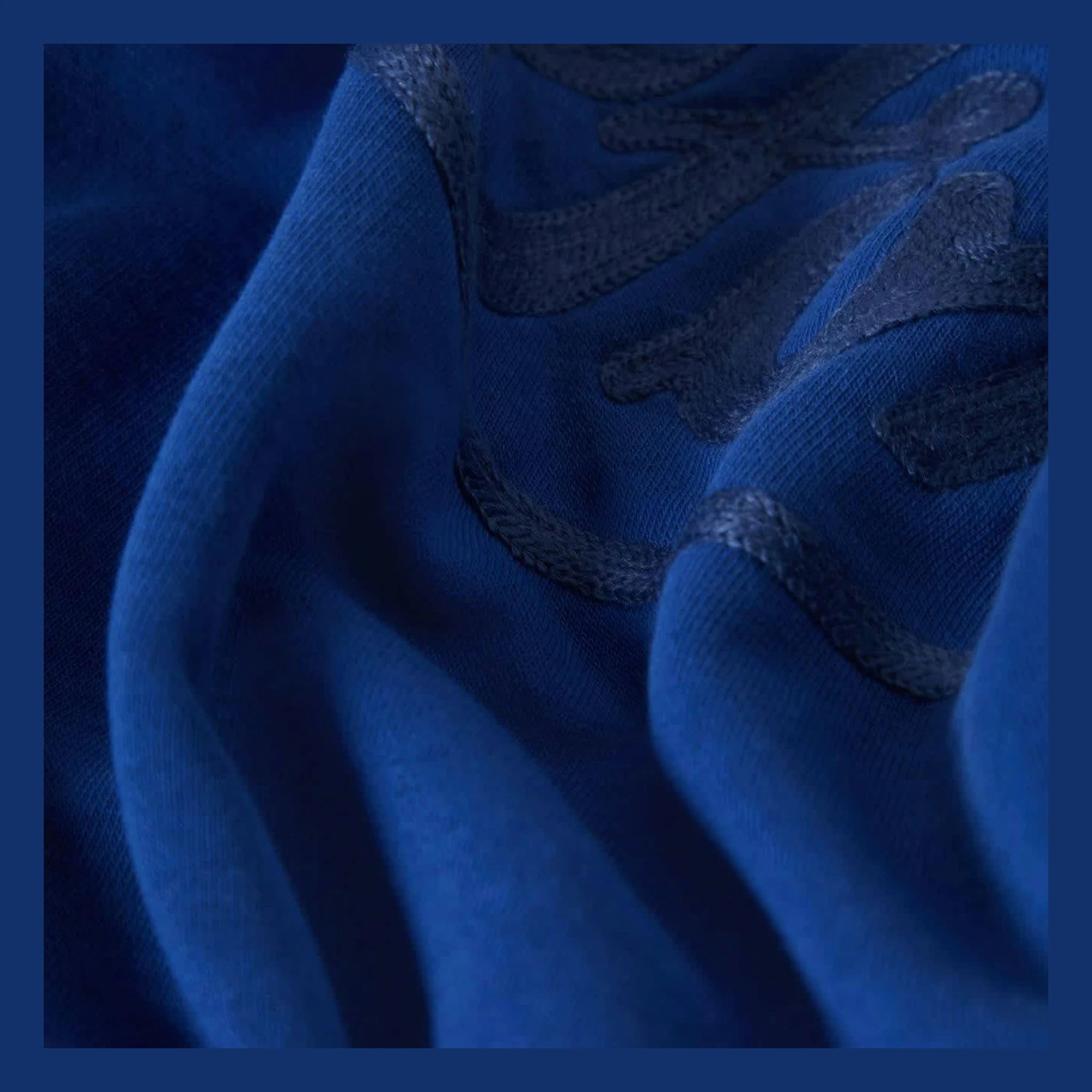 Close-up of Ford Number One Fleece Crew Ford Blue Crewneck showing Charcoal racing stripes on blue ribbed crewneck sleeves -