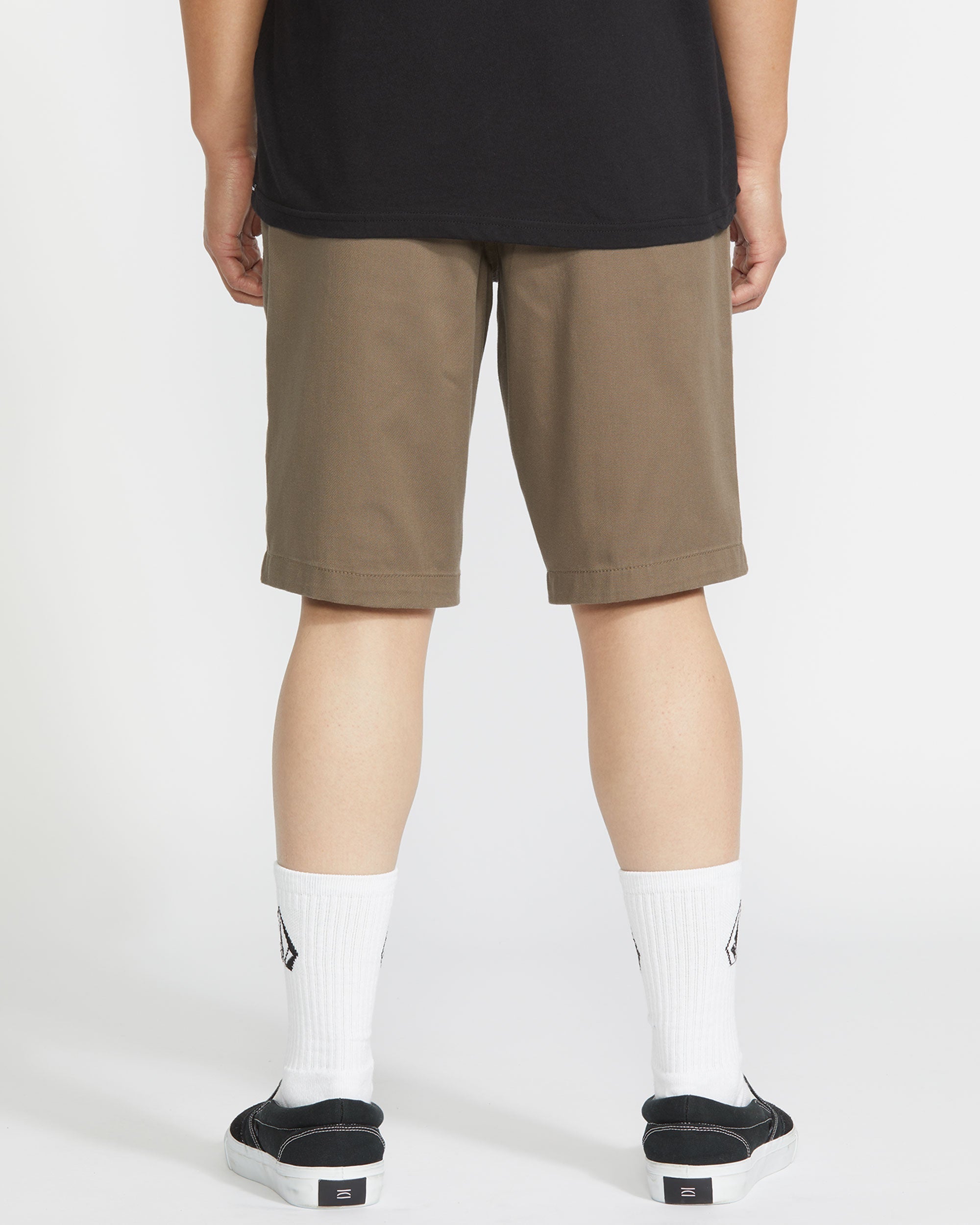 Person wearing Frickin Modern Short Shorts Black Shorts, Khaki shorts styled with black shirt, white socks and black