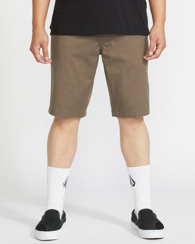 Person wearing Frickin Modern Short Shorts Black Shorts, Khaki shorts styled with black shirt, white ribbed socks, and black