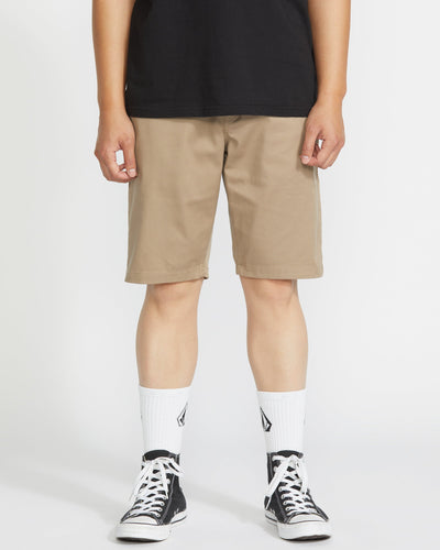 Person wearing Frickin Modern Short Shorts Black Shorts, Khaki shorts styled with black tee, white crew socks, and black