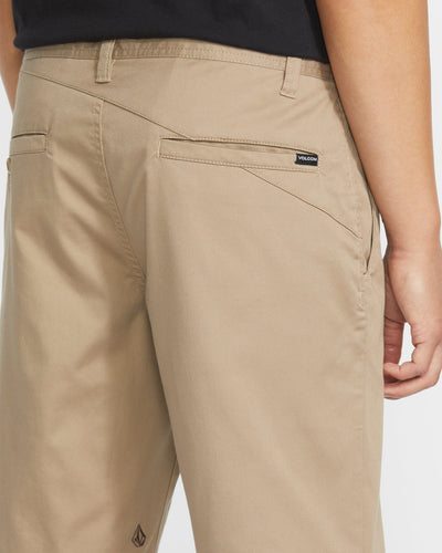 Person wearing Frickin Modern Short Shorts Black Shorts, Khaki shorts worn casually with black shirt indoors - Slowride