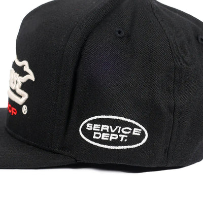 Close-up of Gilmore Black Hat showing White embroidered oval "SERVICE DEPT." patch on black cap crown - Slowride Supply