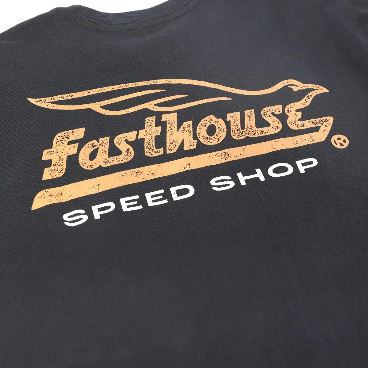 Close-up of Gilmore Black Tee showing Distressed gold speedshop graphic with streaked texture and white text below -