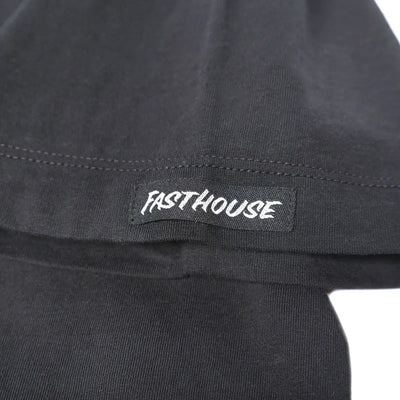 Close-up of Gilmore Black Tee showing White embroidered text on black sleeve with visible stitch detail and seaming -