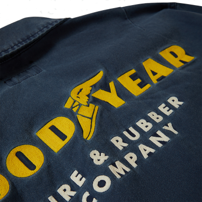 Close-up of Goodyear Trademark LW Washed Navy Jacket showing Embroidered yellow and cream text with winged tire graphic on