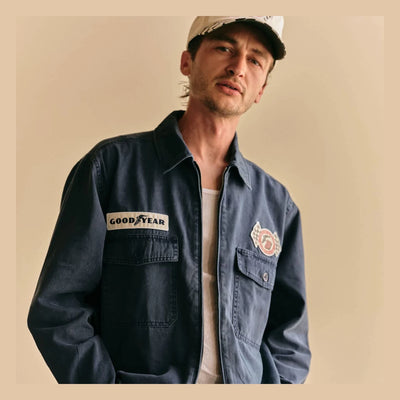 Person wearing Goodyear Trademark LW Washed Navy Jacket, Neutral studio setting with cream backdrop and overhead lighting -