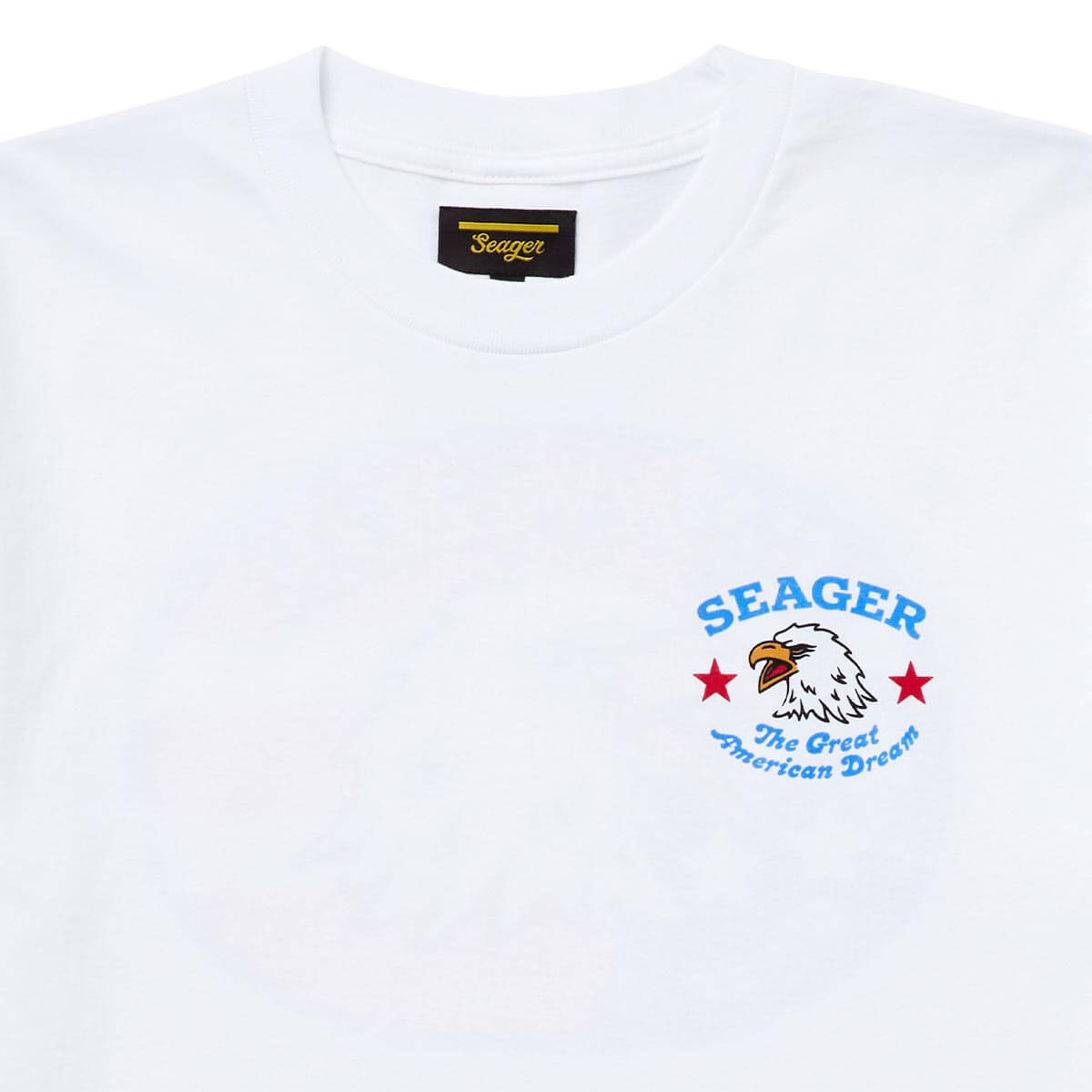 Close-up of Great American Dream White Tee showing White tee with embroidered eagle head, red stars, and blue curved text