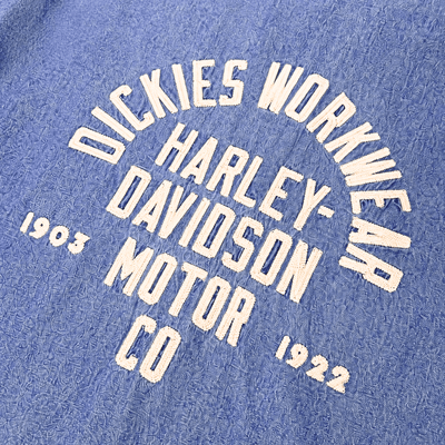 Close-up of Hdxdickies Chambray Work Shirt Light Wash Denim S/S Woven S/S Woven showing Cream-colored circular text graphic