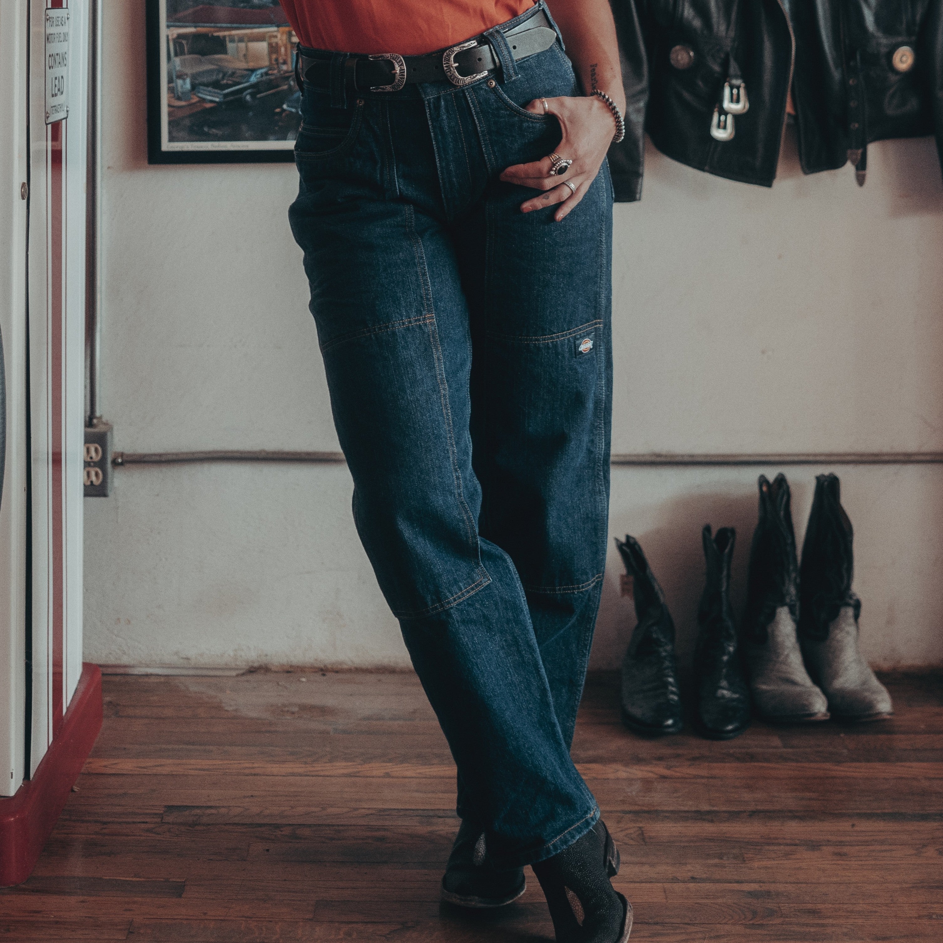 Person wearing Hdxdickies Denim Pant RNB Pants Pants, Garage interior with vintage racing memorabilia and wooden flooring -