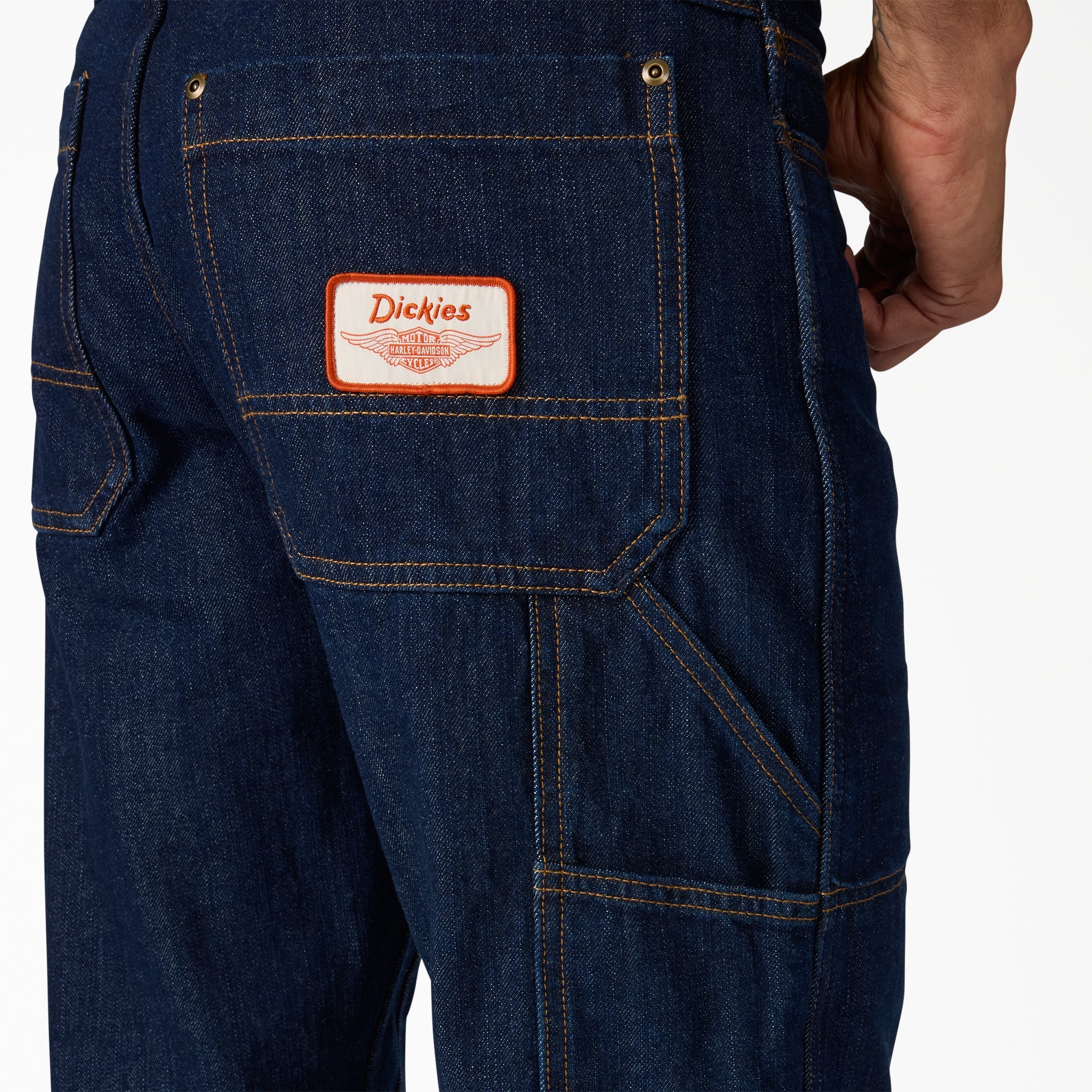 Close-up of Hdxdickies Denim Pant RNB Pants Pants showing Orange and white woven label patch with winged graphic on front